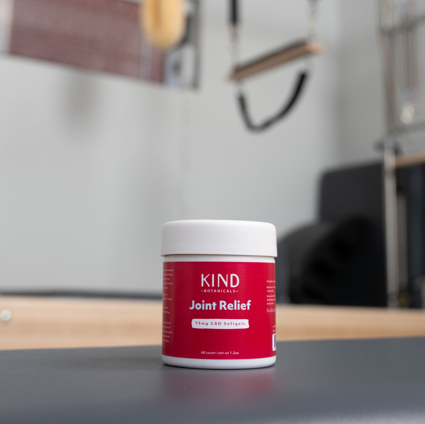 Red and white container labeled 'KIND Joint Relief' on a surface with a blurred background