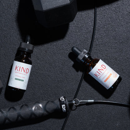 Kind CBD orange and mint Tincture on gym floor with weights 
