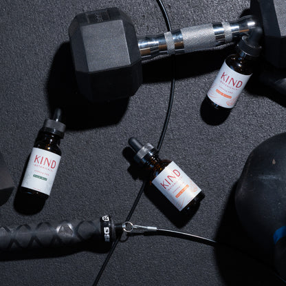 Kind CBD Tinctures on gym floor with weights 