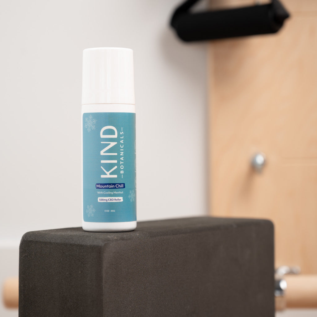 Bottle of KIND Botanicals on a black block with a blurred background