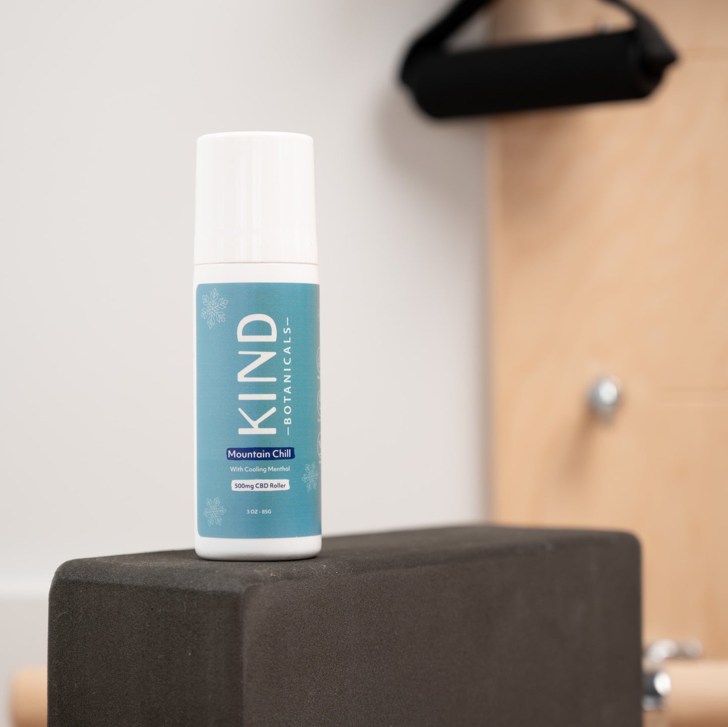 Bottle of KIND Botanicals on a black block with a neutral background