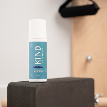 Bottle of KIND Botanicals on a black block with a neutral background