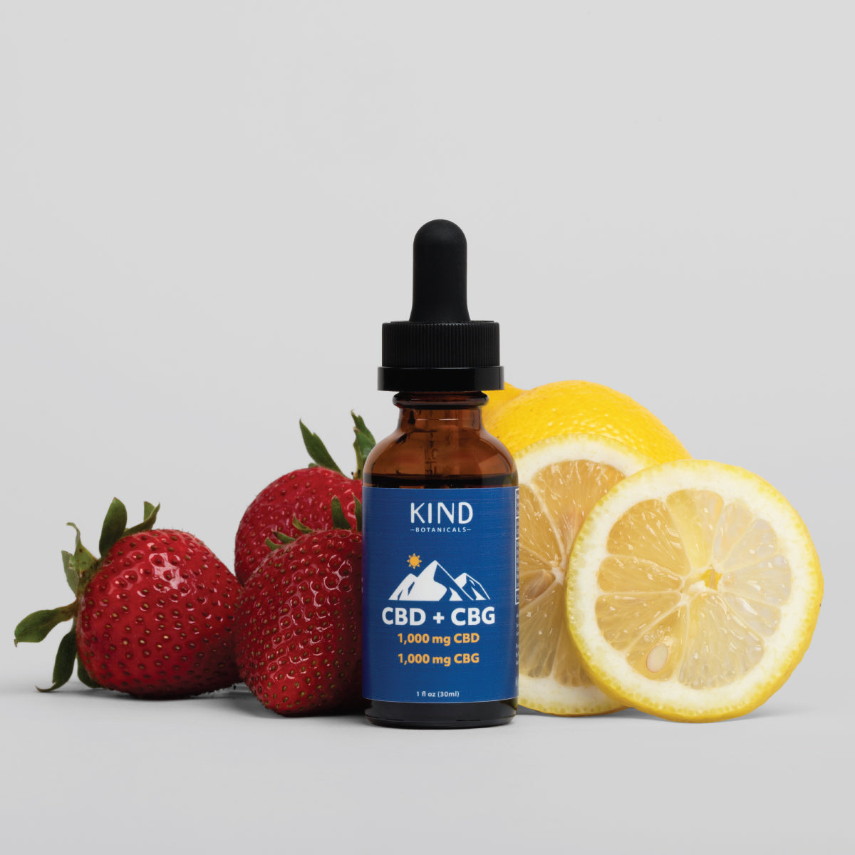 CBD + CBG tincture sitting with strawberries and lemons
