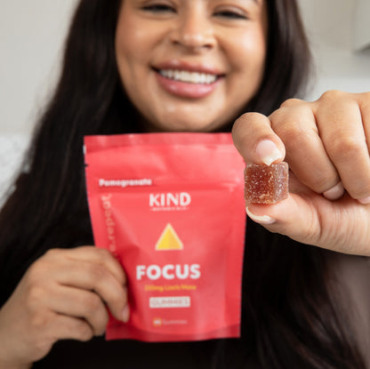 Women holding a KIND Focus gummy 