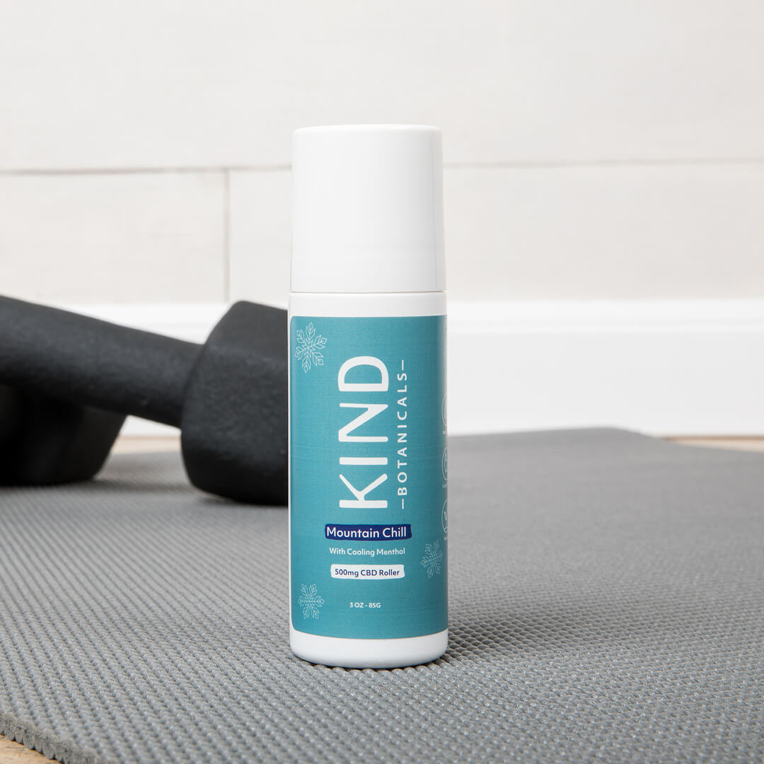 Kind Botanicals CBD Roll On sitting on yoga mat. 